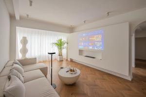 a living room with a white couch and a tv at Shanghai Hills & Serendipity Homestay in Shanghai