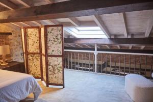 1 dormitorio con balcón con cama y ventana en Alojamiento y Visita a Bodega Miradorio Incluida, en Casasola