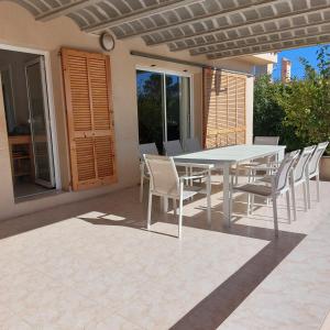 a white table and chairs on a patio at Casa La Rana in Calafat