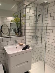 een witte badkamer met een wastafel en een douche bij Windsor Royal Retreat Luxury 1BED Apartment in Windsor +4 foto's