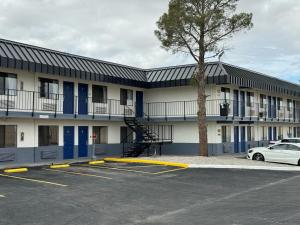 a building with a tree in a parking lot at Days Inn by Wyndham El Paso Airport East in El Paso