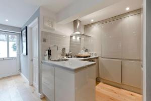 a white kitchen with a sink and a refrigerator at Royal Windsor Central 1 Bed Gem 2 Bath Private Terrace Shared Garden in Windsor