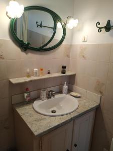 ein Bad mit einem Waschbecken und einem Spiegel in der Unterkunft Sous les pins de Vaison in Vaison-la-Romaine