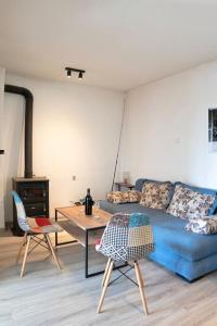 a living room with a blue couch and a table at JG Sunny Balcony apartment Skadar Lake in Podgorica