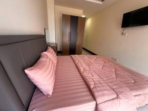 a bed with pink sheets and a pink pillow at Ideal Budget and Cozy Private Studio with Amazing Pool by SYM C738 in Phnom Penh
