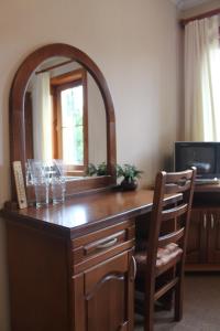 a dining room table with chairs and a mirror at Guest House Todorini kashti in Koprivshtitsa