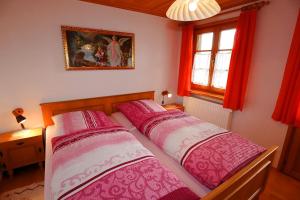 two beds in a bedroom with red curtains at Haus Rosa in Todtmoos
