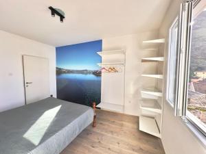 a bedroom with a bed and a large window at JG Sunny Balcony apartment Skadar Lake in Podgorica