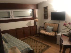 a bedroom with a bed and a chair and a flat screen tv at Hotel Portofoz in Porto
