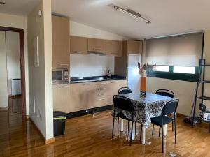a kitchen with a table and chairs in a room at ÁTICO EN AGUIÑO(RIBEIRA) CON WIFI in Ribeira