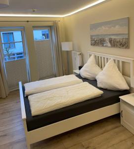 - une chambre avec 2 lits et des oreillers blancs dans l'établissement Traumhafte Ferienwohnung "Seeküste" in Cuxhaven - Duhnen in 1A LAGE im Haus Elbe 1 !!! 50m zum Strand !!!, à Cuxhaven