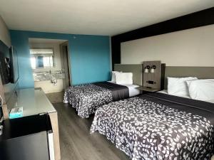 a hotel room with two beds and a bathroom at Days Inn by Wyndham El Paso Airport East in El Paso