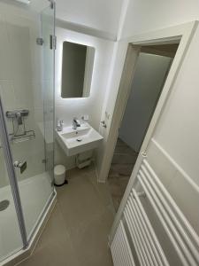 La salle de bains blanche est pourvue d'un lavabo et d'une douche. dans l'établissement Traumhafte Ferienwohnung "Seeküste" in Cuxhaven - Duhnen in 1A LAGE im Haus Elbe 1 !!! 50m zum Strand !!!, à Cuxhaven