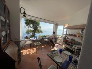a man sitting at a table on the balcony of a house at La Terrazza sul Mare in Capri