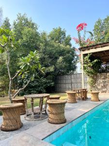 a patio with tables and chairs next to a swimming pool at THE BAREWITHIN HOUSE in Jaipur