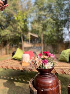a vase filled with flowers sitting on a table at THE BAREWITHIN HOUSE in Jaipur