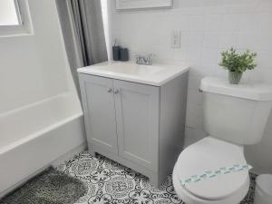 a white bathroom with a toilet and a sink at Arpe 4plex in Fort Lauderdale