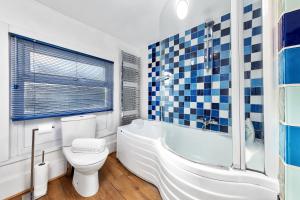 uma casa de banho com um WC, uma banheira e um lavatório. em Balcony Blue Theme 1 Bedroom Central London Luxury Flat Near Hyde Park! Accommodates up to 6! Double Sofa Bed and Next to Station! em Londres