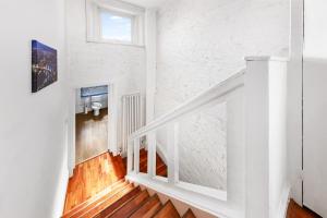 escalera blanca en una habitación blanca con suelo de madera en Balcony Blue Theme 1 Bedroom Central London Luxury Flat Near Hyde Park! Accommodates up to 6! Double Sofa Bed and Next to Station!, en Londres