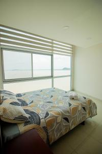 una camera con un letto di fronte a una grande finestra di Vista frente al rio, exclusivo con piscina a Guayaquil