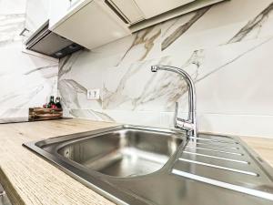 a stainless steel sink in a kitchen with marble walls at Casa Ari, Beautiful Ocean View in Morro del Jable