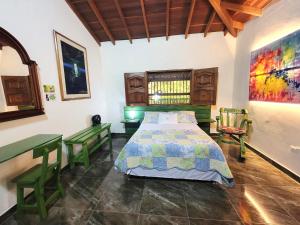 ein Schlafzimmer mit einem Bett und zwei Stühlen darin in der Unterkunft PaloSanto, Casa Rural in Jardin