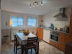 a kitchen with a table with a bowl of fruit on it at Les Papillons in Tennenbronn