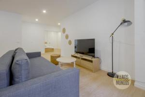 Smart Apartment 3pax en Madrid Rio con Parking في مدريد: غرفة معيشة مع أريكة زرقاء وتلفزيون