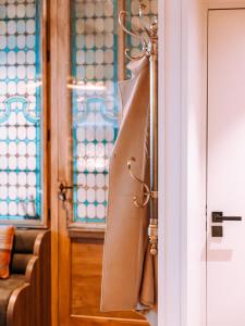 a tie hanging on a door next to a window at L'Académie Hôtel Lyon in Lyon