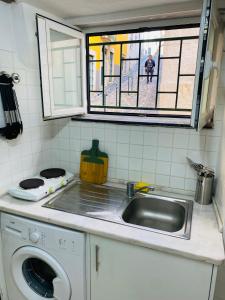 a kitchen with a sink and a washing machine at Alfama Charm Apartments - Authentic Lisbon Experience in Lisbon