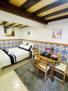 a bedroom with two beds and a table and chairs at Alfama Charm Apartments - Authentic Lisbon Experience in Lisbon