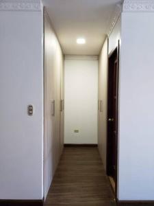 um corredor com portas brancas e piso de madeira em Casa Pepita em Vilcabamba