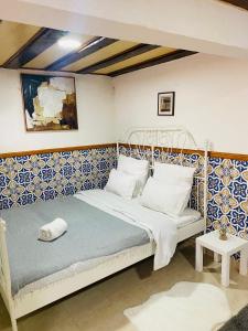 a bedroom with a white bed with blue and white tiles at Alfama Charm Apartments - Authentic Lisbon Experience in Lisbon