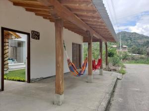 um alpendre com uma rede de descanso pendurada num edifício em Casa Pepita em Vilcabamba