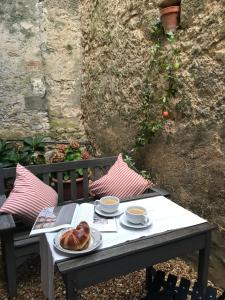 einen Tisch mit einem Teller Brot und zwei Tassen Kaffee in der Unterkunft The Apartment in Saint-Jean-dʼAngély