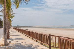 a wooden walkway to the beach with a palm tree at Casa LadoMar em Mundaú por Carpediem in Mundaú