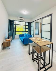 ein Wohnzimmer mit einem blauen Sofa und einem Tisch in der Unterkunft Jesselton Quay by Adara Suites in Kota Kinabalu