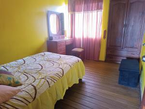 um quarto com uma cama, uma cómoda e uma televisão em Habitaciones en vivienda ubicada en urbanización privada em Cuenca