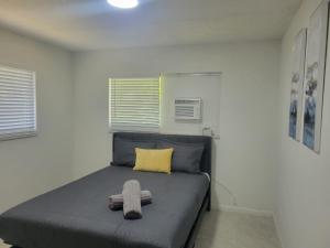 a bedroom with a bed with a yellow pillow at Arpe 4plex in Fort Lauderdale