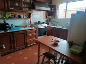 uma cozinha com um fogão e uma mesa em Habitaciones en vivienda ubicada en urbanización privada em Cuenca