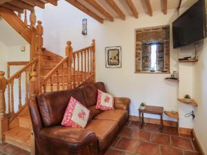 a living room with a leather couch and a staircase at The Abraham in Moone