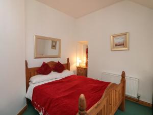 a bedroom with a wooden bed with red pillows at The Abraham in Moone