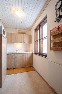 una cocina con armarios de madera y una ventana en Historisches Stadthaus - Wohnen im Herzen von Weitra, en Weitra