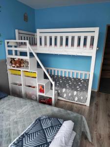a bedroom with two bunk beds and a blue wall at Apartament W sam Raz in Słupsk