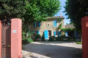 ein Steinhaus mit blauen Fensterläden und einem Tor in der Unterkunft Superbe mas proche centre-ville in Salon-de-Provence