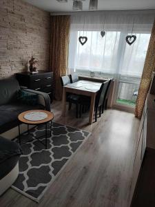 uma sala de estar com uma mesa e um sofá em Apartament W sam Raz em Słupsk