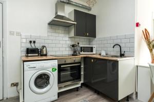 uma cozinha com uma máquina de lavar roupa e uma máquina de lavar roupa em Shoreditch-bricklane-convenient-central-liverpoolstreet em Londres