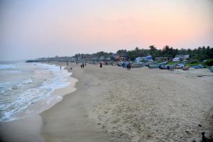 grupa ludzi spacerujących po plaży w obiekcie DE Villa Breeze @ Beach side w mieście Puducherry