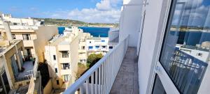 a balcony with a view of the ocean and buildings at Seaside Serenity - Luxe Penthouse - near the beach in Mellieħa