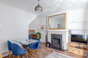 a living room with a glass table and blue chairs at Serene 2BD Flat wPrivate Patio Old Street! in London